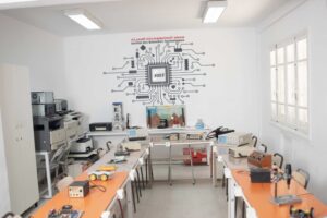 Salle de maintenance moderne et bien équipée au Centre privée INT Tunisie, étudiants appliquant leurs compétences techniques dans un environnement pratique sécurisé